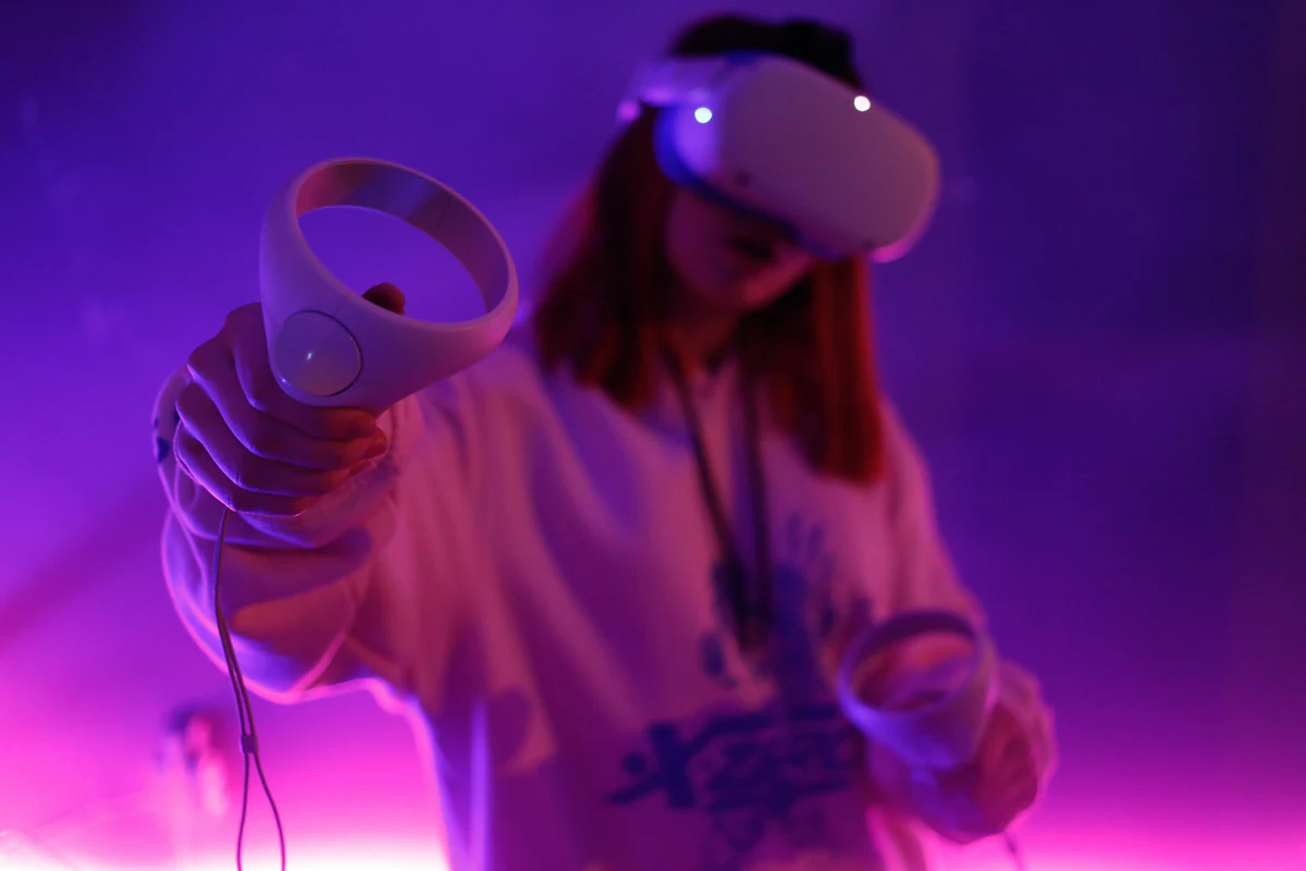 Gamer in a VR headset holding motion controllers under purple light