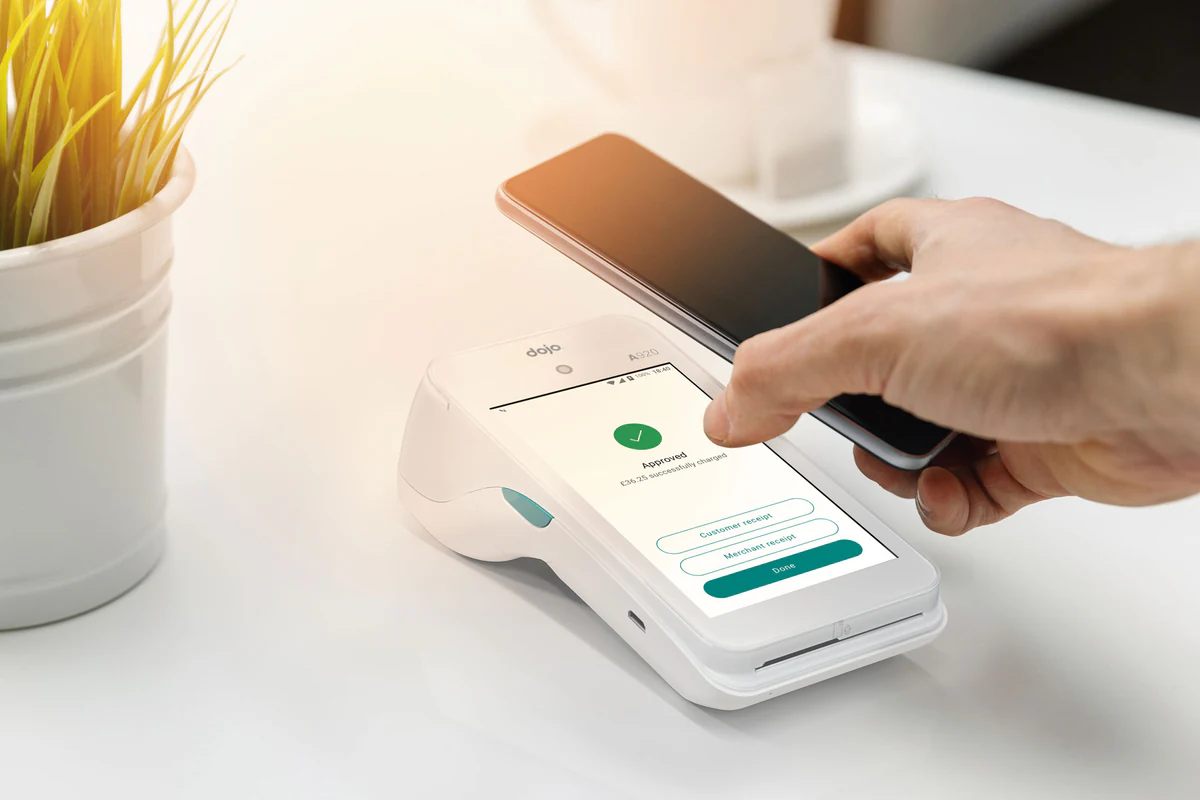 Dojo Go contactless card machine CGI hero render with hand and phone